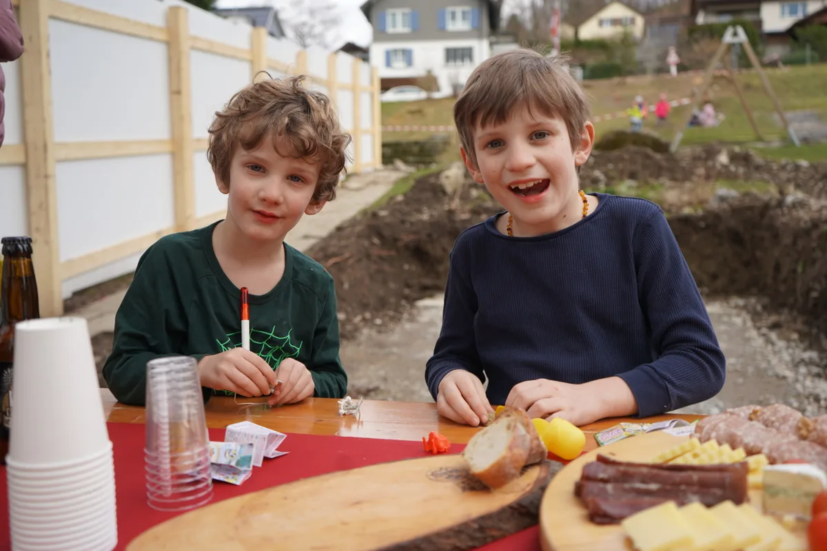 Zwei Jungs lächeln hinter dem Apéro-Buffet in die Kamera.